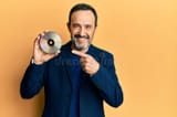 middle-age-hispanic-man-holding-compact-disc-smiling-happy-pointing-hand-finger-middle-age-hispanic-man-holding-compact-221161244