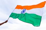 close-up-man-hand-holding-india-flag-blue-sky-background_53476-485