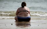 American woman sitting on beach