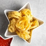 dried-pasta-mushrooms-and-vegetables-on-stone-grrey-background-table-top-view-with-copy-space-2550379190