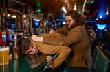soccer-fans-fight-aggressive-man-pulling-guy-bar-counter-friends-conflict-pub-furious-people_266732-32217