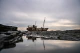 abandoned-rusty-fishing-boat-on-rocky-shore