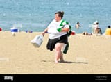 obese-woman-walking-on-the-beach-in-wisconsin-AJFNEG-3643561977