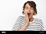 close-up-of-tired-young-woman-yawning-feeling-fatigue-sleepy-face-early-morning-standing-in-striped-t-shirt-over-white-background-2GA8RA4