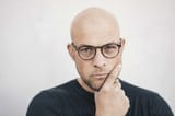 portrait-of-starring-bald-man-wearing-glasses-KNSF06209