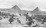 An Australian soldier plays with a regimental mascot at Mena Camp, December 1914