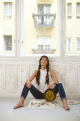 50901520-pretty-casual-woman-sitting-on-floor-front-of-window-legs-wide-open