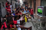 flamego-fans-watch-soccer-game-on-tv-in-a-favela-da-mare
