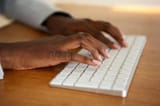 close-up-female-hands-typing-computer-keyboard-african-american-130537538