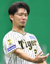 何？