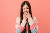 young-cool-chinese-woman-laughing-about-something-covering-mouth-with-hands_1187-29424