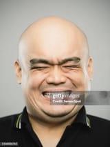 portrait-of-real-chinese-adult-man-with-extreme-expression-and-eyes-closed