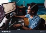 stock-photo-young-indian-guy-using-computer-554969716