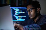 indian-man-with-glasses-is-sitting-front-laptop-computer-focused-his-work-indian-man-with-glasses-focused-expression-coding-laptop_538213-109869