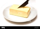 a-slab-of-butter-with-a-knife-on-a-white-plate-AKTYCH