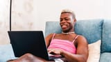 transgender-man-using-laptop-computer-while-relaxing-sitting-sofa-home_124437-2021