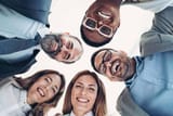 smiling-business-team-bending-over-in-a-circle