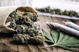 marijuana-buds-joints-and-leaves-on-wooden-table-to-represent-marijuana-allergy