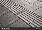 stock-photo-line-of-hazard-warning-tactile-paving-along-the-edge-of-platform-at-the-train-station-tactile-1066658504