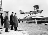 Winston_Churchill_and_the_Secretary_of_State_for_War_waiting_to_see_the_launch_of_a_de_Havilland_Queen_Bee_radio-controlled_target_drone%2C_6_June_1941._H10307