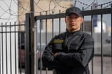 portrait-male-security-guard-with-barbed-wire-fence_23-2150368756