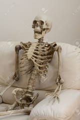 69214136-skeleton-sitting-in-white-chair-against-white-wall