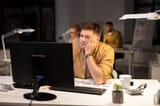 tired-bored-man-with-computer-night-office_380164-217338