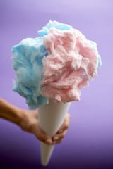 00679469-Hand-Holding-Pink-and-Blue-Cotton-Candy-Purple-Background