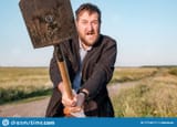 angry-white-bearded-man-swinging-shovel-showing-aggression-towards-people
