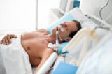 stable-condition-side-view-portrait-patient-mechanical-ventilator-lying-bed-under-white-sheets-middle-aged-man-sleeping-128102592