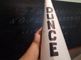 bigstock-Hand-Holding-Dunce-Cap-Hat-In-313781875
