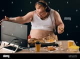 obese-man-talking-with-a-computer-close-up-portrait-isolated-black-backgroundlifestyle-concept-pastime-2CCXBFM