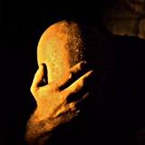 bald man rubbing head in despair