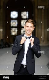 young-european-man-standing-and-posing-wearing-black-suit-and-bow-tie-2C2A7WH