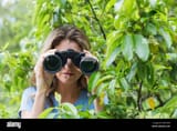 young-woman-looking-through-binocular-FRGTKW