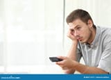 bored-man-watching-tv-zapping-sitting-couch-home-80071473