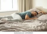 relaxed-man-sleeping-on-stomach-260nw-2276338365