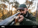 hunter-man-aiming-his-shotgun-at-camera-2J9KYRN