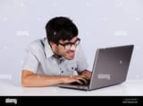 nerd-teenager-working-with-his-laptop-with-a-funny-face-BXPHKY