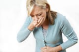 senior-women-feeling-sick-holding-hand-over-her-mouth
