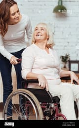 pleasant-woman-taking-care-of-her-grandmother-in-wheelchair-HBBMKG