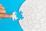 hand-put-the-last-piece-of-jigsaw-puzzle-to-complete-the-mission-completing-final-task