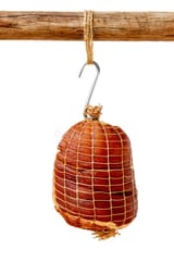 smoked-boneless-ham-hock-wrapped-netting-pork-hanging-hook-wooden-pole-isolated-white-77484879