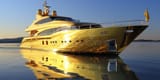 golden-yacht-gold-super-sailing-along-coast-luxurious-millionaire-boat-sunny-day-275468761