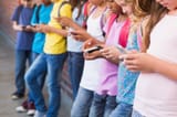 cute-pupils-using-mobile-phone-royalty-free-image-473838686-1551308780