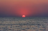 beautiful-sunset-with-red-sun-hiding-horizon-sea_98725-2131