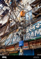 chaotic-tangle-of-wires-for-street-lighting-electricity-supplies-and-telephone-cables-in-a-street-in-the-old-city-of-delhi-northern-india-T5W491