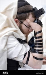 a-close-up-of-an-orthodox-jewish-man-wearing-tefillin-and-a-tallis-at-a-synagogue-in-cambria-heights-queens-new-york-T12K5T